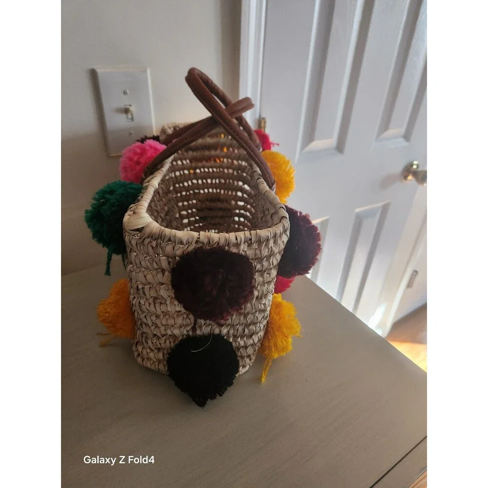 Beautiful woven straw bag with colorful pom-poms